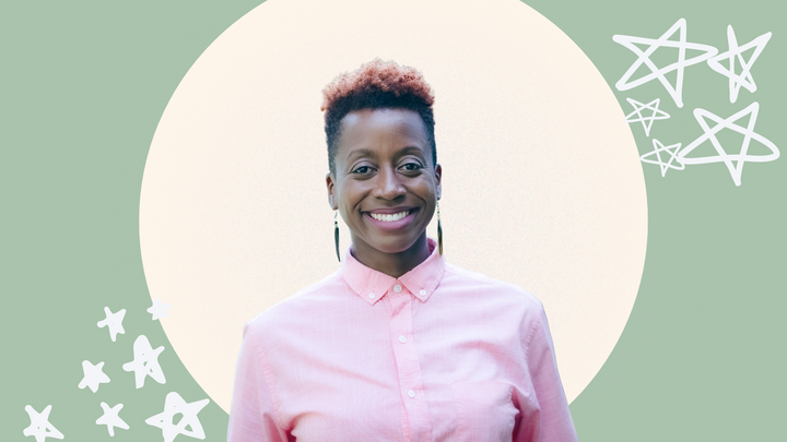 MK Abadoo, a medium brown-skinned African American person smiles. They wear a pink  shirt and have a short, tapered cut.